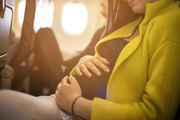 飛行機に乗る妊婦